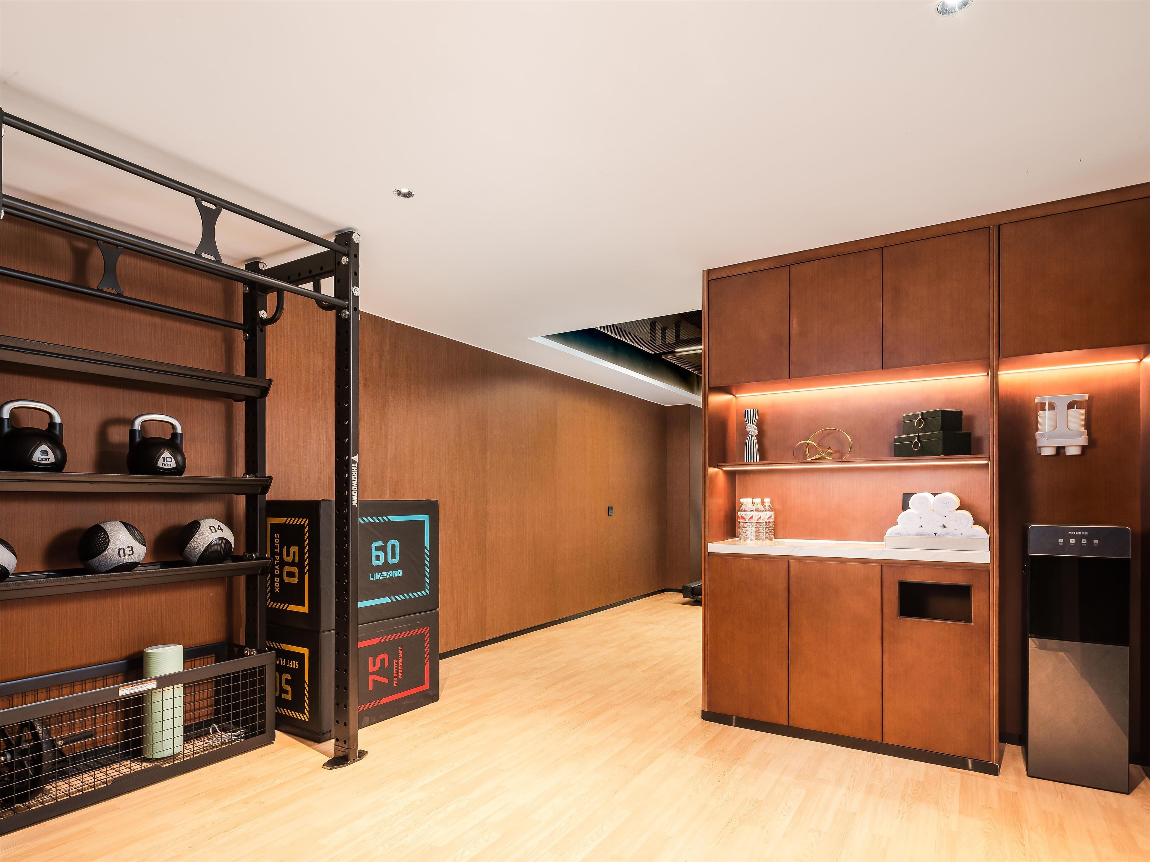A modern kitchen with wooden cabinets, a built-in oven, and a water dispenser.