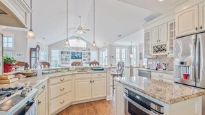 A spacious kitchen with white cabinetry, a central island, and stainless steel appliances. - Spacious 4BR Home near Cape May Beach | Sleeps 10! (Cape May)
