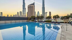 Piscina en la azotea con un horizonte urbano de fondo, incluyendo el Burj Khalifa.