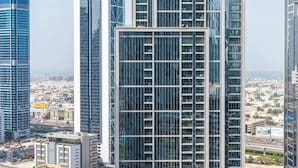 A high-rise building with a modern glass facade, surrounded by other tall buildings.