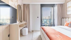 Een moderne hotelkamer met een groot bed, een televisie, een bureau en uitzicht op de stad.