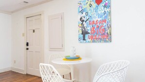 A room with a white door, a round table with two white chairs, and a colorful abstract painting on the wall. - The Place on Pierce by Apex Short Term Stays (Oxford)