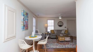A living room with a white sofa, a coffee table, and a rug. There is a painting on the wall and a window with blinds. - The Place on Pierce by Apex Short Term Stays (Oxford)