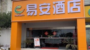 A hotel entrance with an orange facade and a sign that reads "Easy Hotel". - Yi An Hotel (Suzhou)