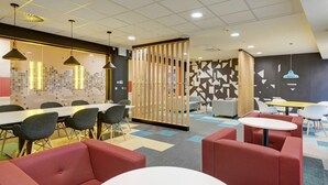 A modern office space with a long table, several chairs, and a partition wall. - New Bridewell (Bristol)
