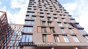 Ein Hochhaus mit einem Schild, auf dem 'CITY CLUB APARTMENTS' steht.