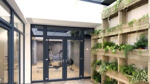 A modern interior with a glass door leading to a room with a desk and chair. - For Students Only Abodus The Walls Southampton - Campus Accommodation (Southampton)