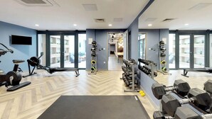 A gym with exercise equipment, a TV, and large windows. - For Students Only Abodus The Walls Southampton - Campus Accommodation (Southampton)