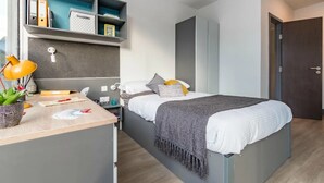 A modern bedroom with a bed, bedside table, desk, and shelving unit. - For Students Only Canvas Capital House in Southampton (Southampton)