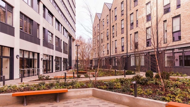 A modern building complex with multiple floors, outdoor seating areas, and landscaped gardens. - For Students Only Canvas Capital House in Southampton (Southampton)