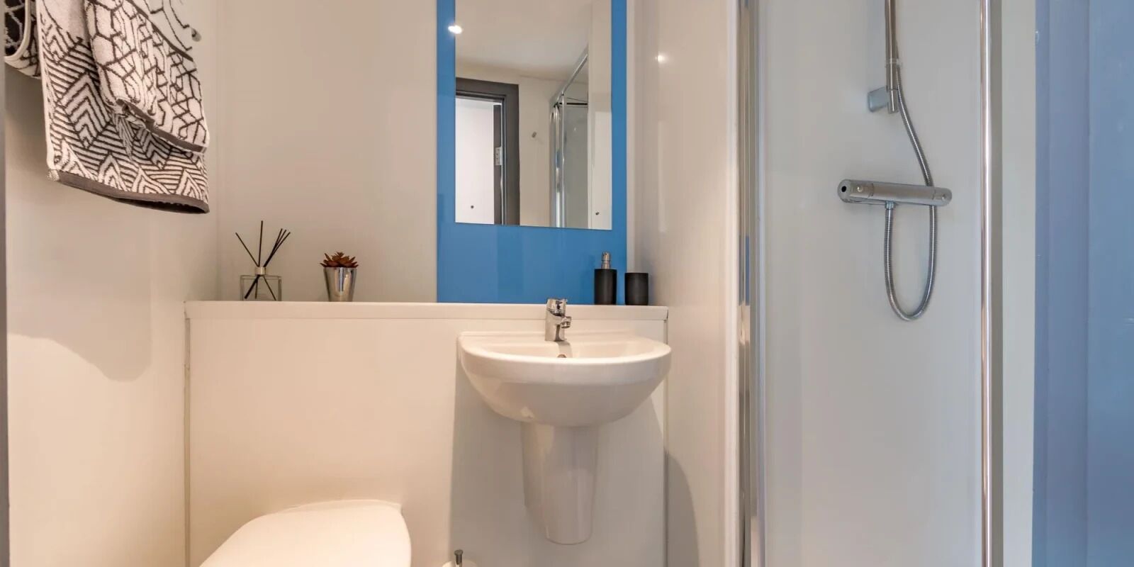 Ein modernes Badezimmer mit Waschbecken, Spiegel und Dusche.