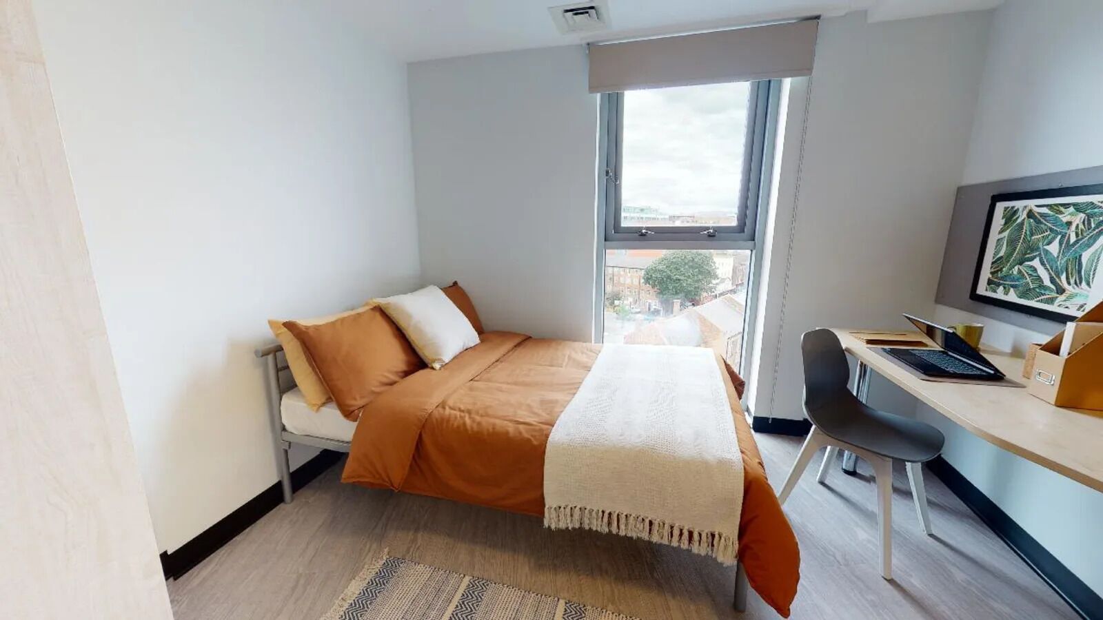 A modern bedroom with a bed, a desk, and a chair.