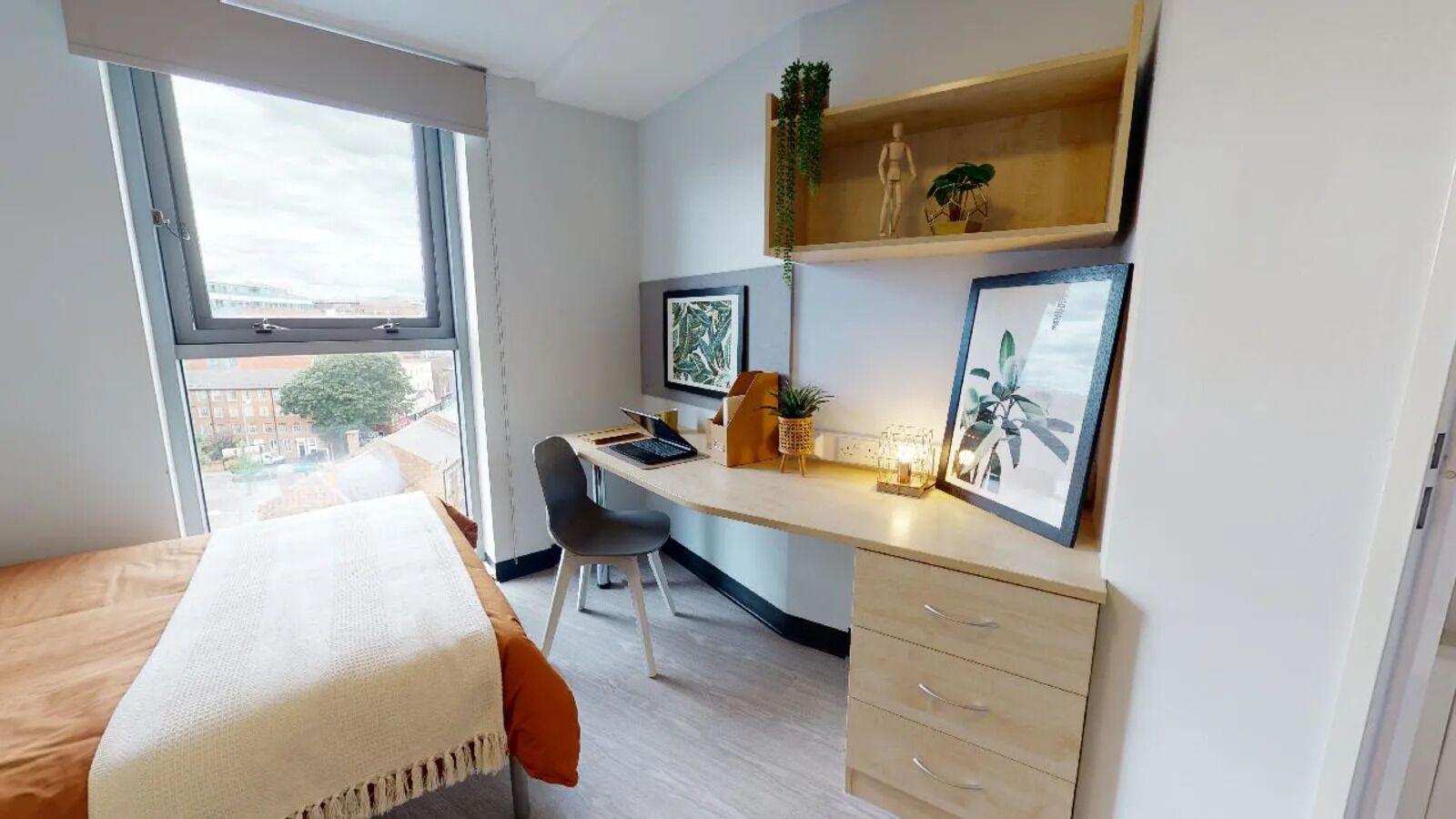 Quarto moderno com cama, escrivaninha e cadeira. Uma janela oferece luz natural e vista para o exterior.