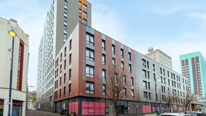 A multi-story building with a mix of modern and traditional architectural styles, featuring large windows and a prominent entrance. - Student Only Oldway Centre (Swansea)
