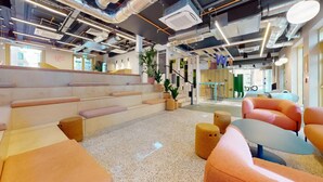 A modern office space with a staircase, seating areas, and a visible reception desk. - For Students Only - Signal Place - Campus Accommodation (Nottingham)