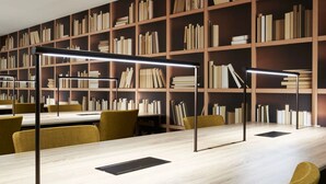 Een moderne bibliotheek met boekenplanken, tafels en stoelen.
