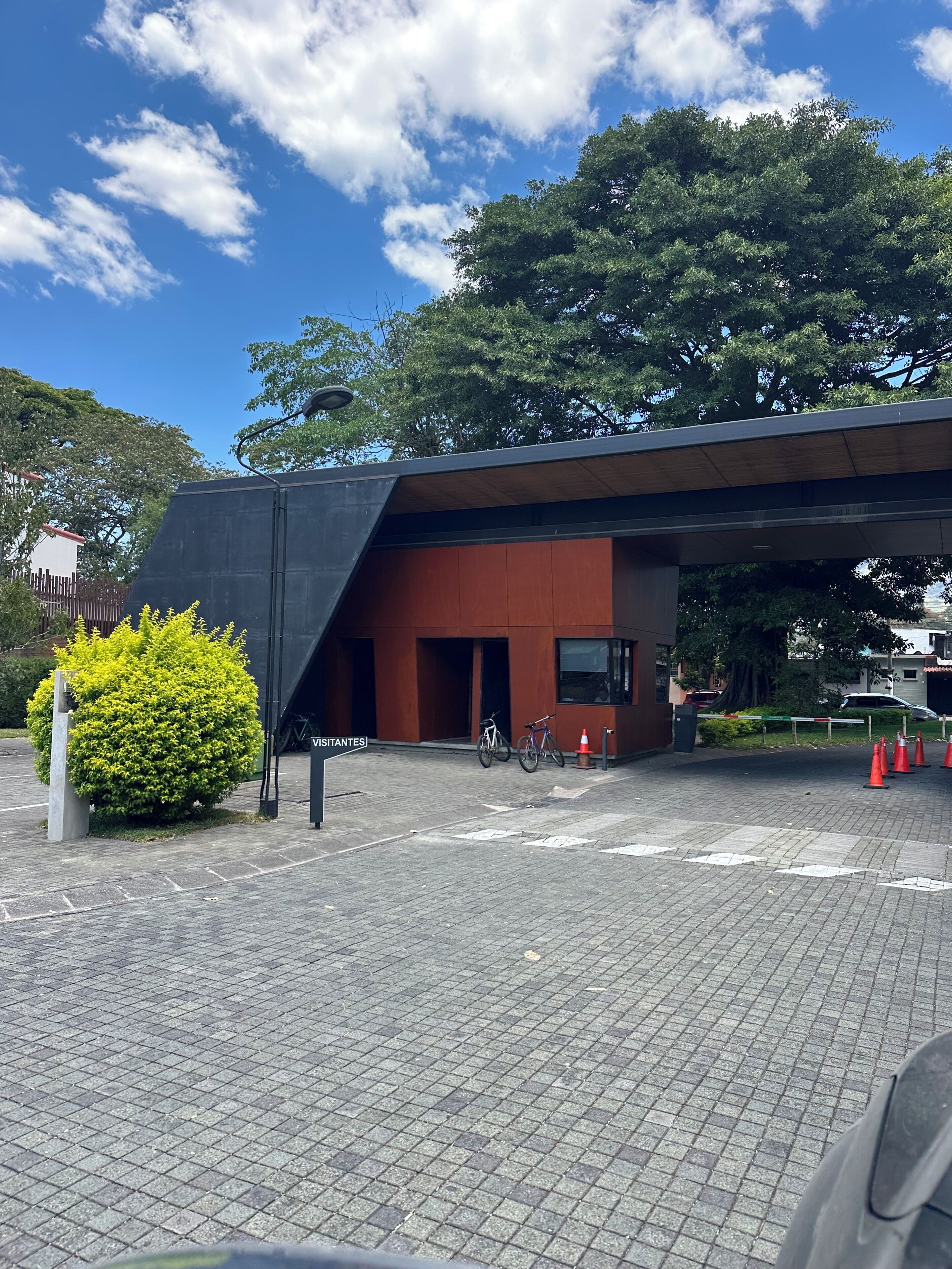 A building with a modern design, a paved entrance area, and a bicycle parked outside.