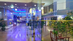 A modern interior with glass partitions, a staircase, and a reception area.