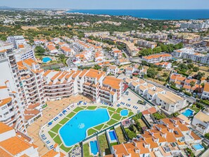 Un quartier rĂ©sidentiel avec des immeubles dâappartements, une piscine et une vue sur la mer.
