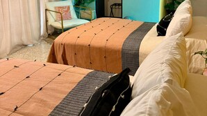 Una habitación de hotel con una cama, una silla, una planta y un televisor.