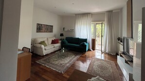 A spacious living room with a sofa, a coffee table, and a television.