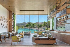 Ein modernes Restaurant mit Blick auf einen Pool, Holzmöbel und Regale mit Küchenutensilien.