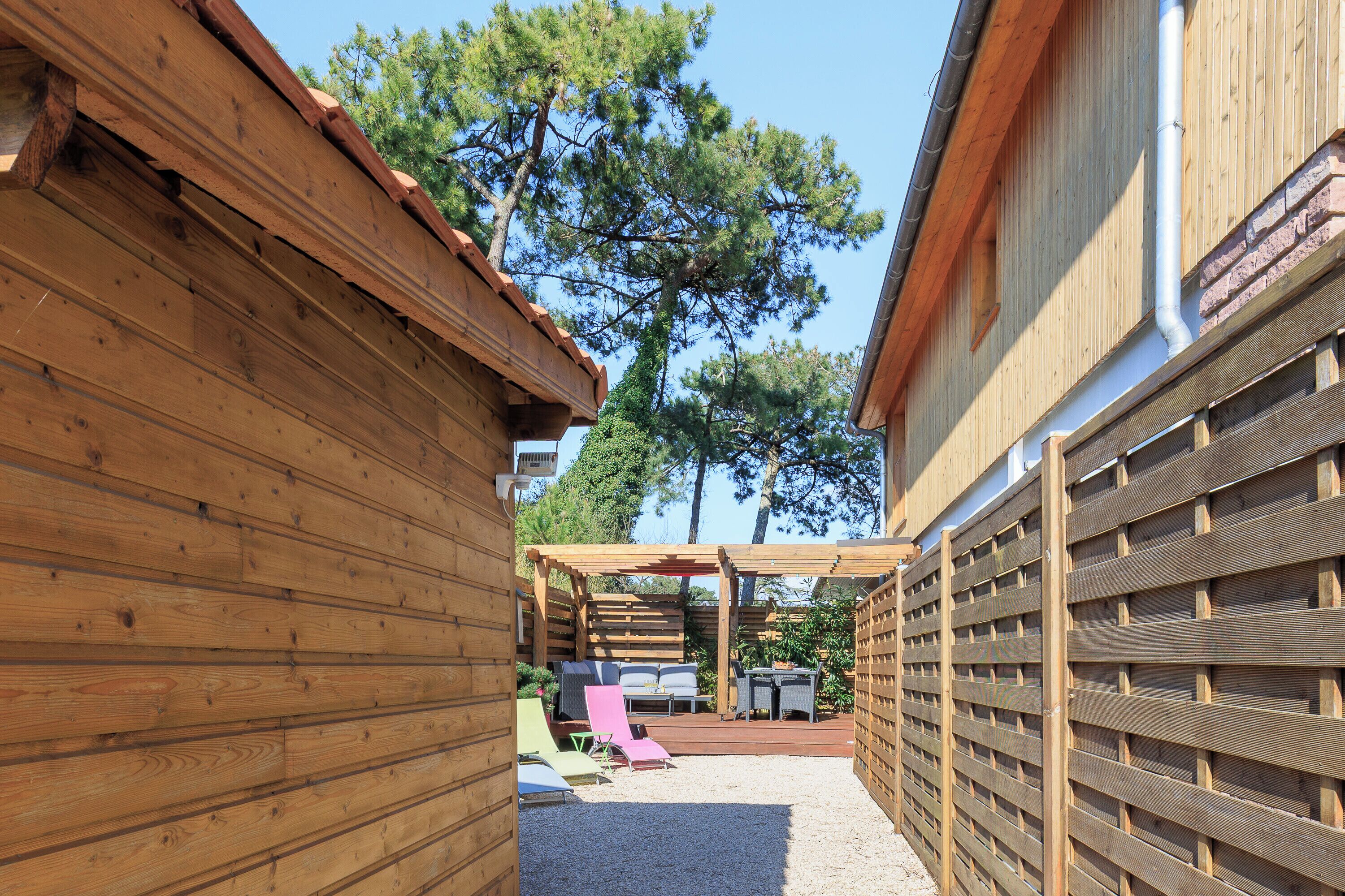 Ein Holzhaus mit überdachter Veranda, inklusive einer Sitzecke mit Stühlen und Tisch.
