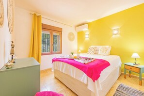 Una camera da letto con un letto, comodini, una finestra e una parete gialla.
