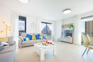 Een moderne woonkamer met een bank, salontafel en uitzicht op de stad.