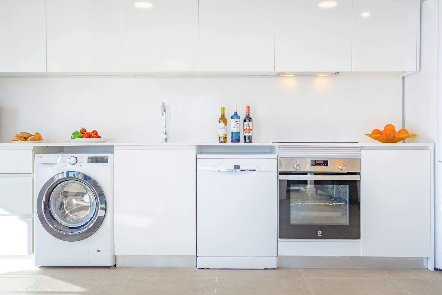 Een moderne keuken met een wasmachine, vaatwasser en oven.