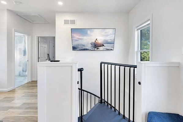 A modern interior with a staircase, a framed picture on the wall, and a view of the outdoors. - 5 Min to Campus and Downtown Morgantown, River View, 3B 2B (Morgantown)