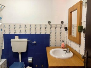 Une salle de bain avec des toilettes, un lavabo et un miroir.