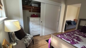 A bedroom with a bed, a chair, a desk, a wardrobe, and a small table with a lamp. - Charming studio in enchanting Napa walking distance to downtown (Napa)