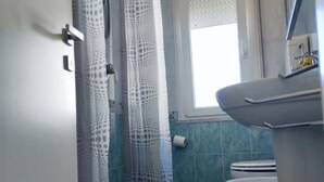 A bathroom with a toilet, a sink, and a window with a curtain. - CN001 - Cesenatico, two-room apartment with balcony and air conditioning (Cesenatico)