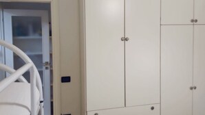 A white room with a bed, a wardrobe, and a door leading to a bathroom. - CN001 - Cesenatico, two-room apartment with balcony and air conditioning (Cesenatico)