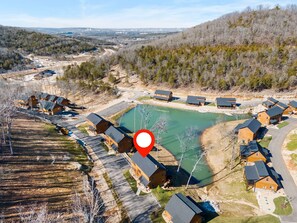 An aerial view of a resort with multiple cabins, a central lake, and surrounding wooded areas. - Cozy Cabin with Water Views, Private Hot Tub, Free Daily Tickets Near Table Rock (Hollister)
