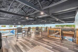Un vaste espace intérieur doté d’une piscine, d’une terrasse en bois et de plusieurs coins salon.