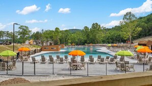 A swimming pool area with lounge chairs and umbrellas, surrounded by a fence. - Private Hot Tub Cabin Near Table Rock Lake with Firepit, Free Tickets & Community Experiences (Hollister)