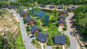 A residential area with houses arranged in a semi-circular pattern around a central water feature. - Private Hot Tub Cabin Near Table Rock Lake with Firepit, Free Tickets & Community Experiences (Hollister)