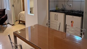 Una cocina moderna con una mesa de comedor de vidrio, sillas de acero inoxidable y un horno empotrado.