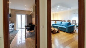 Un appartement moderne comprenant une cuisine, un coin repas et un salon.