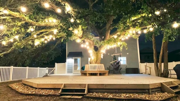 An outdoor patio area with a wooden deck, a bench, and a swing set. - Ultimate vacay home, walk to beach, fenced in yard (North Myrtle Beach)