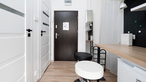 A modern bathroom with a white toilet, a wooden vanity, and a black chair.