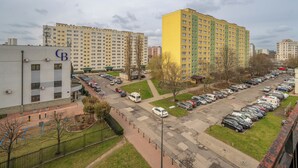 Un parking rempli de voitures et un bâtiment sur lequel on peut lire l’inscription « CB ».