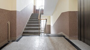 Ein modernes Interieur mit Treppe, Handläufen und einer Tür.