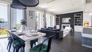 Ein modernes Wohnzimmer mit Essbereich, Kamin und Blick auf die Stadt.