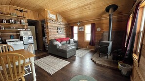 Un intérieur de chalet chaleureux comprenant une cuisine, un coin repas et un salon.