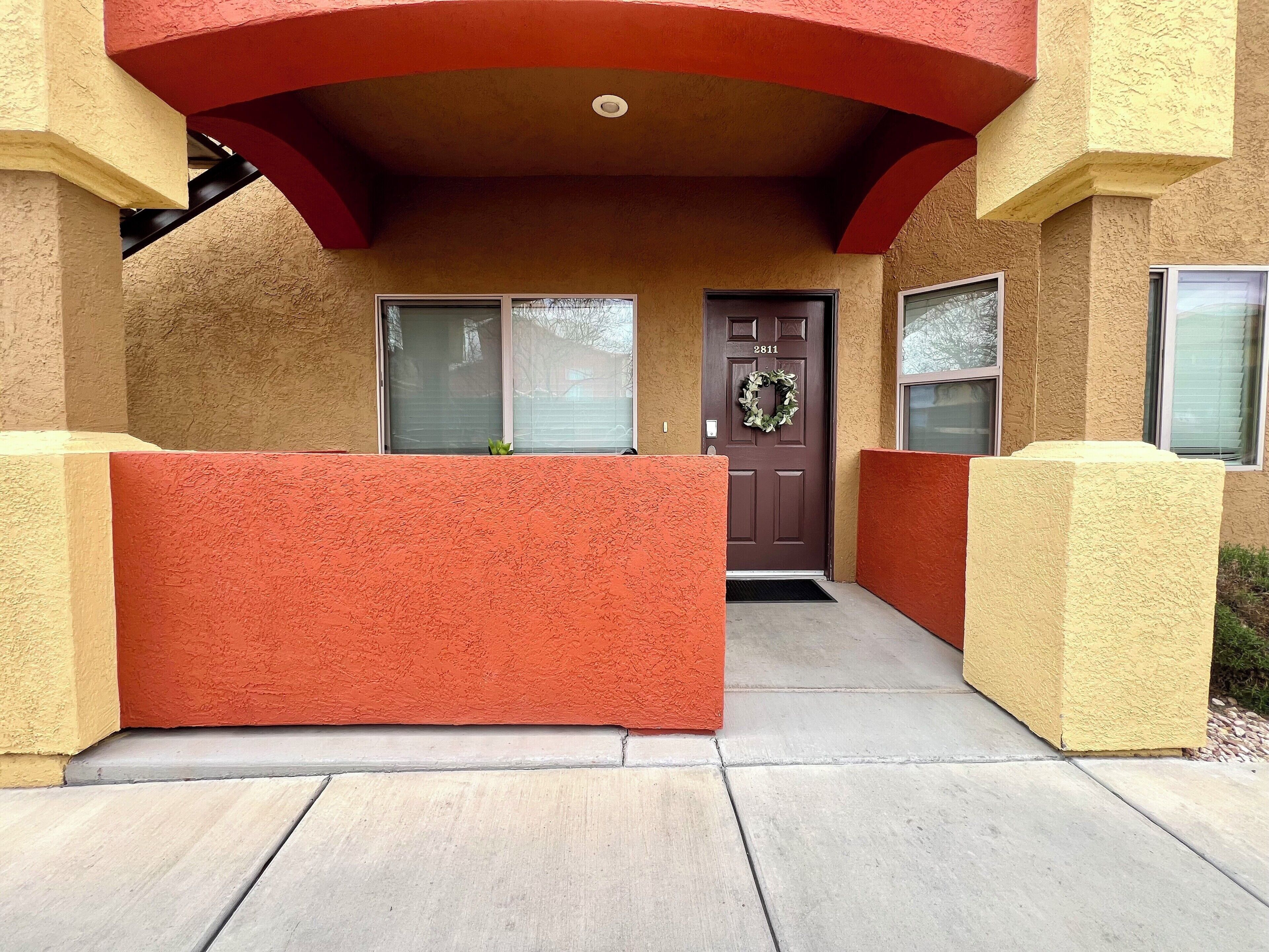 A building entrance with a brown door, a wreath, and a number 2811 on the door.