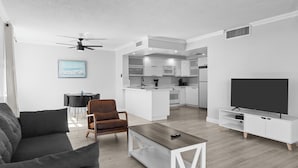 A modern living room with a sofa, coffee table, and TV stand. - Bay Harbor Sunset Apt 5A (Bay Harbor Islands)
