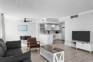 A modern living room with a sofa, coffee table, and TV stand.